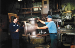 Archival photo of two technicians working on valve